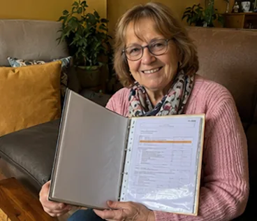 Brigitte M. sur son canapé avec dossier familial ouvert